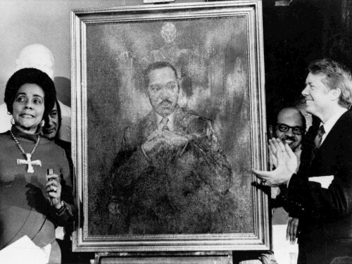 FILE - Coretta Scott King, widow of slain civil rights leader Martin Luther King Jr., speaks at an unveiling of a portrait of Martin Luther King by artist George Mandus on Feb. 18, 1974, while Gov. Jimmy Carter, right, looks on.