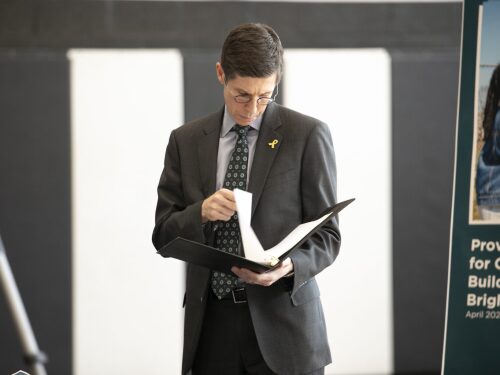 Providence Mayor Brett Smiley reviews a document before speaking on the city’s school transition plan during a press conference at the Zuccolo Recreation Center on Federal Hill on Thursday, April 10, 2025.