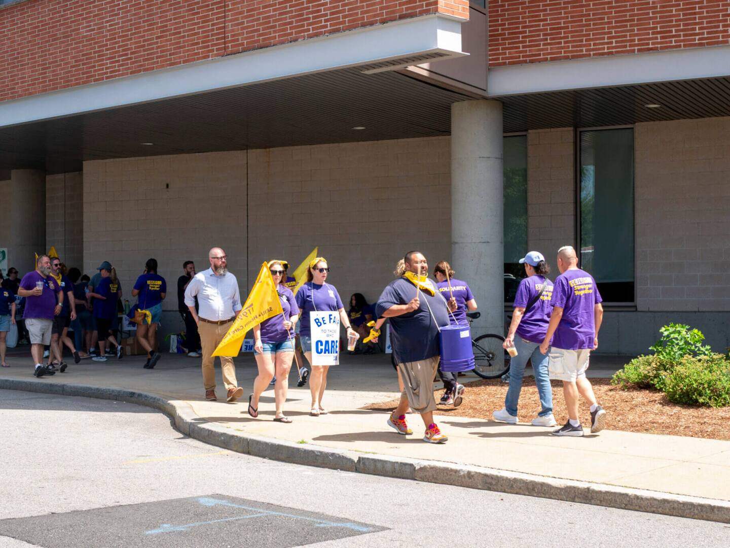 Unionized workers at Women & Infants Hospital march outside the hospital on Wednesday, July 23, 2025, during an informational picket supporting striking Butler Hospital staff and calling for workplace improvements at both hospitals, which are owned by Care New England.